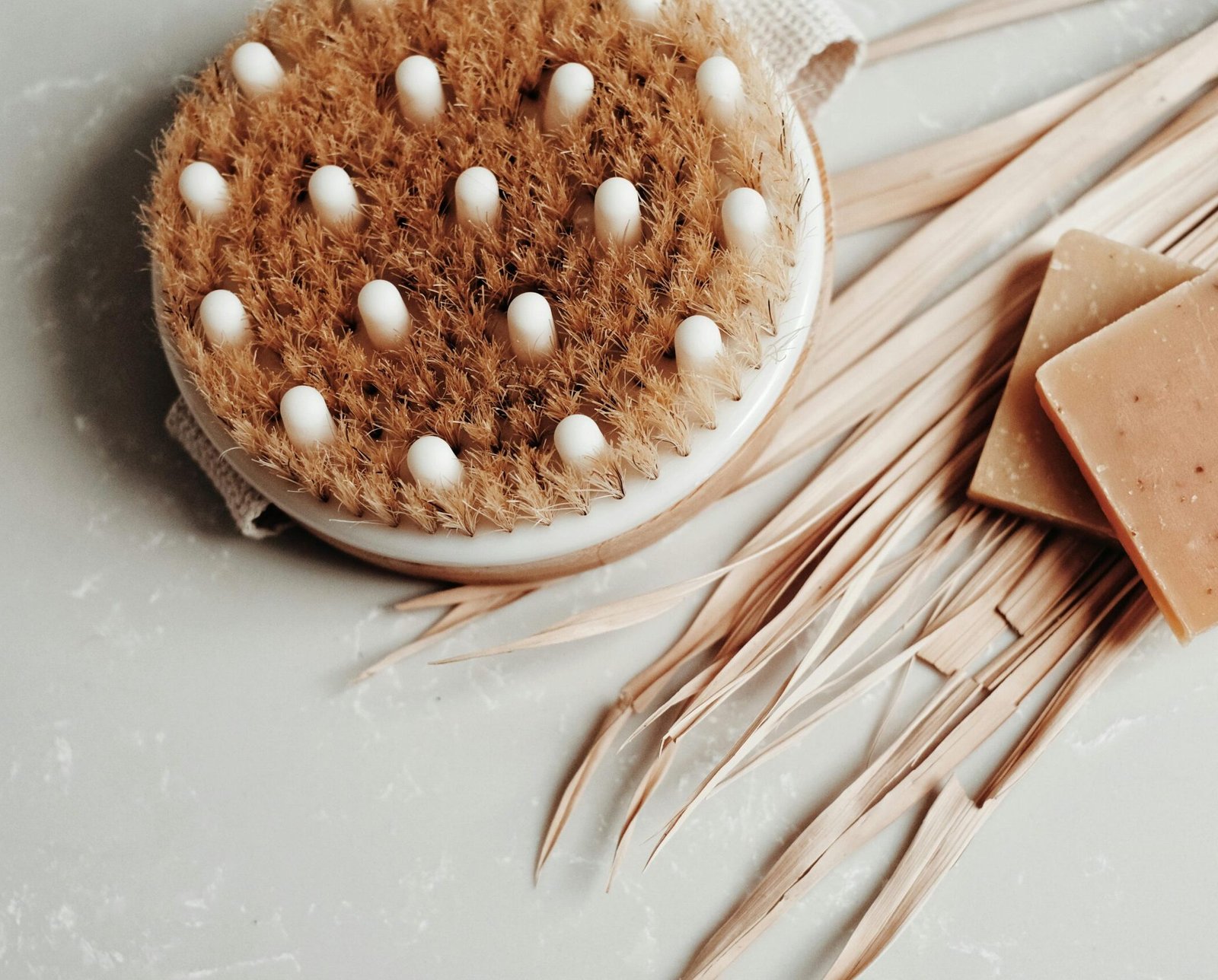 Eco-friendly body brush and soap on marble, promoting sustainable hygiene practices.